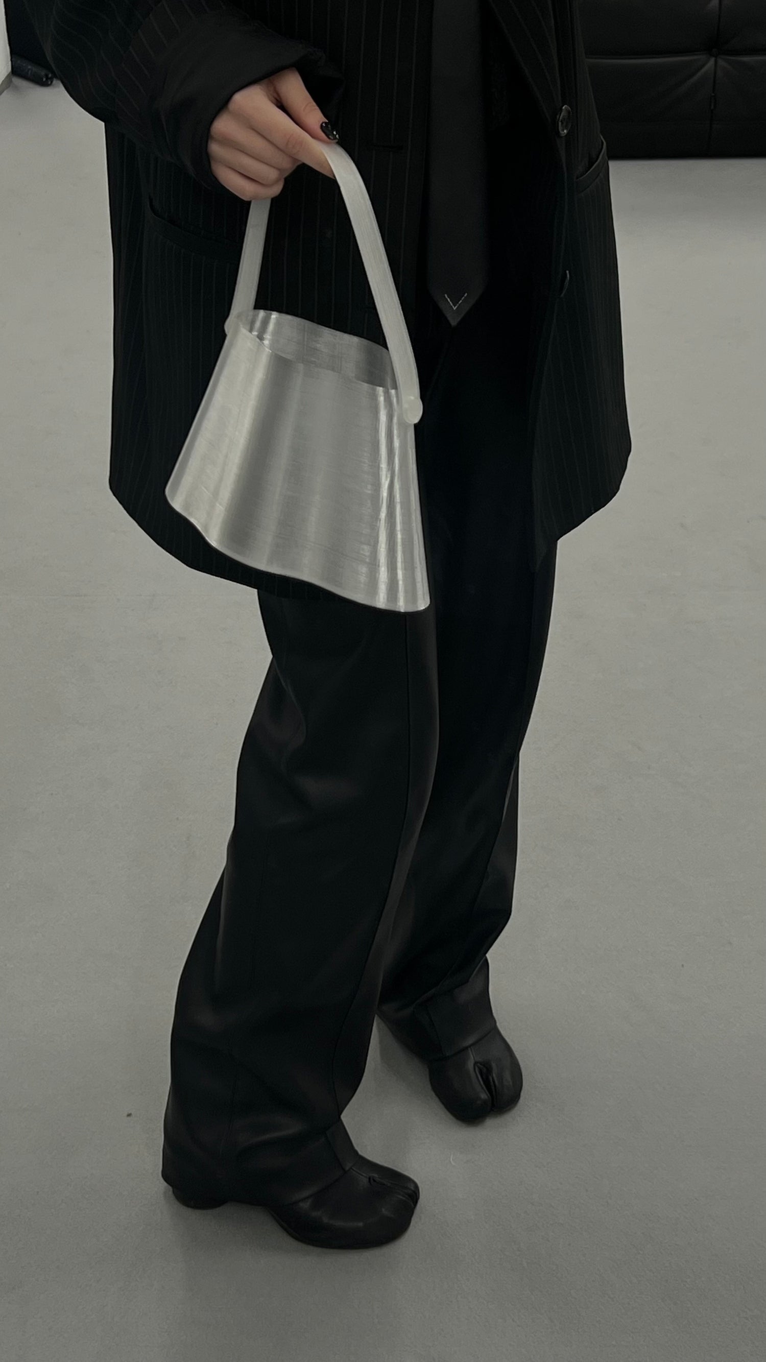 Shell Midi Bag in Ice, fully 3D-printed from recycled transparent TPU. Unique, edgy design with layered texture, combining sustainability and eco-conscious craftsmanship.