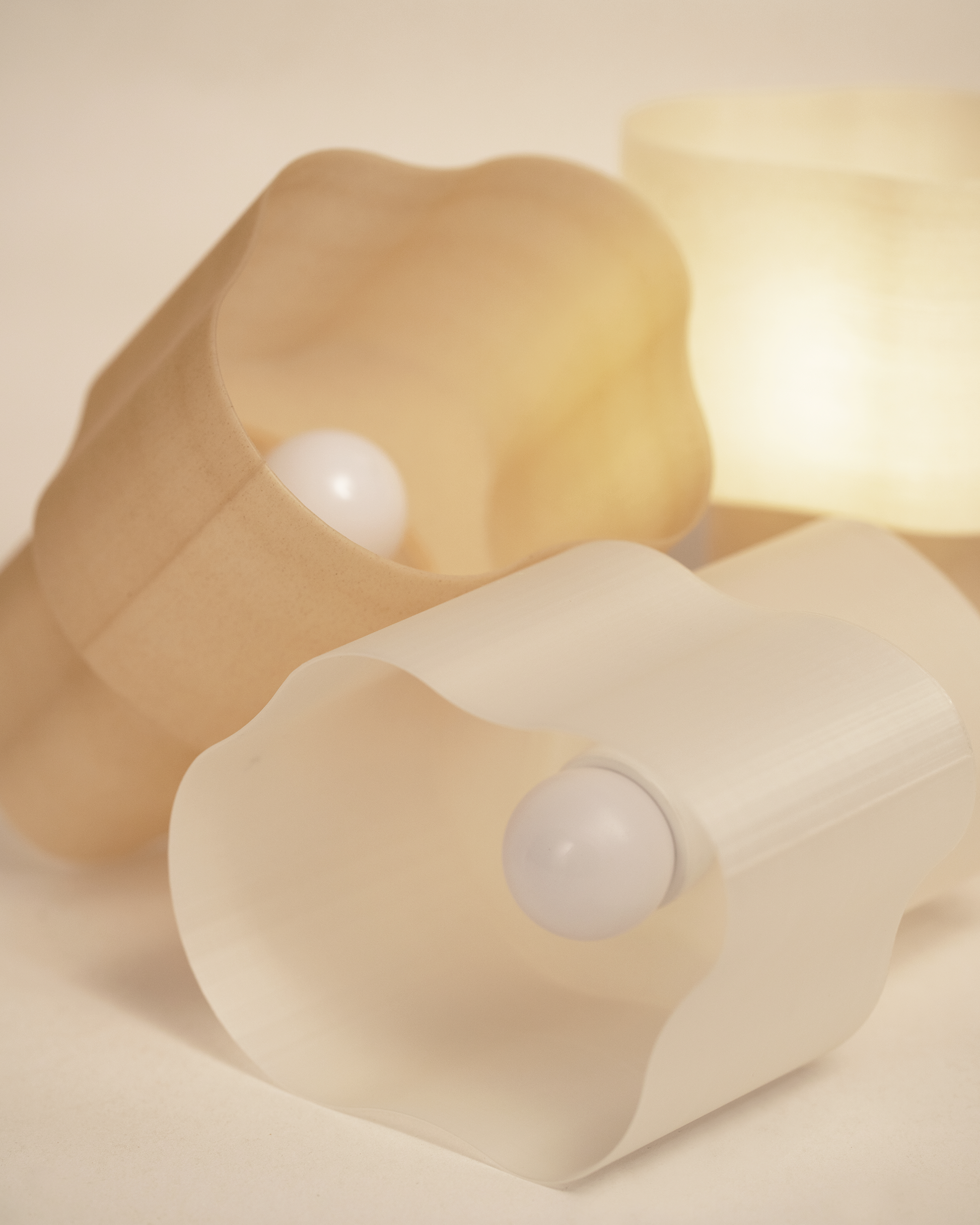 Collection of Cloudy Lamps in various earthy colors, 3D-printed from PLA filaments mixed with natural by-products like mussel shells, oysters, scallops, and wheat offcuts. Eco-friendly, with unique textures and colors created through recycling waste from agriculture and catering. Provides ambient, decorative light.